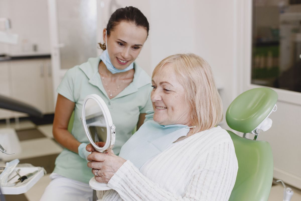 Dental implants vs dentures Kharghar, senior patient smiling with dentist, Reform Dental Clinic Sector 15