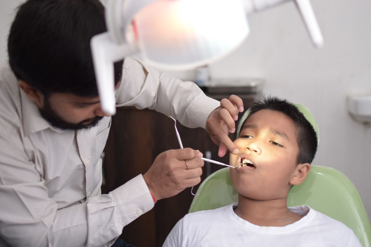 Fluoride treatment Kharghar, dentist checking a child's teeth at Reform Dental Clinic Sector 15