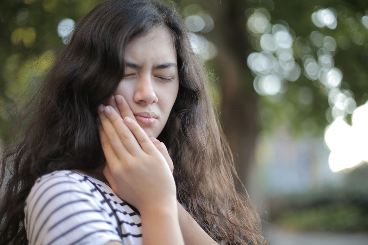 sensitive teeth Kharghar woman wincing at tooth sensitivity before a check-up at Reform Dental Clinic Sector 15