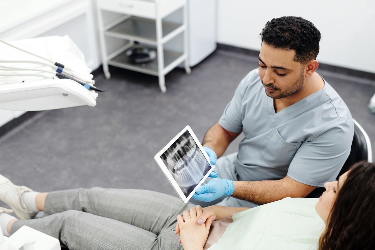 wisdom tooth removal Kharghar dentist showing a dental x-ray to a patient at Reform Dental Clinic Sector 15